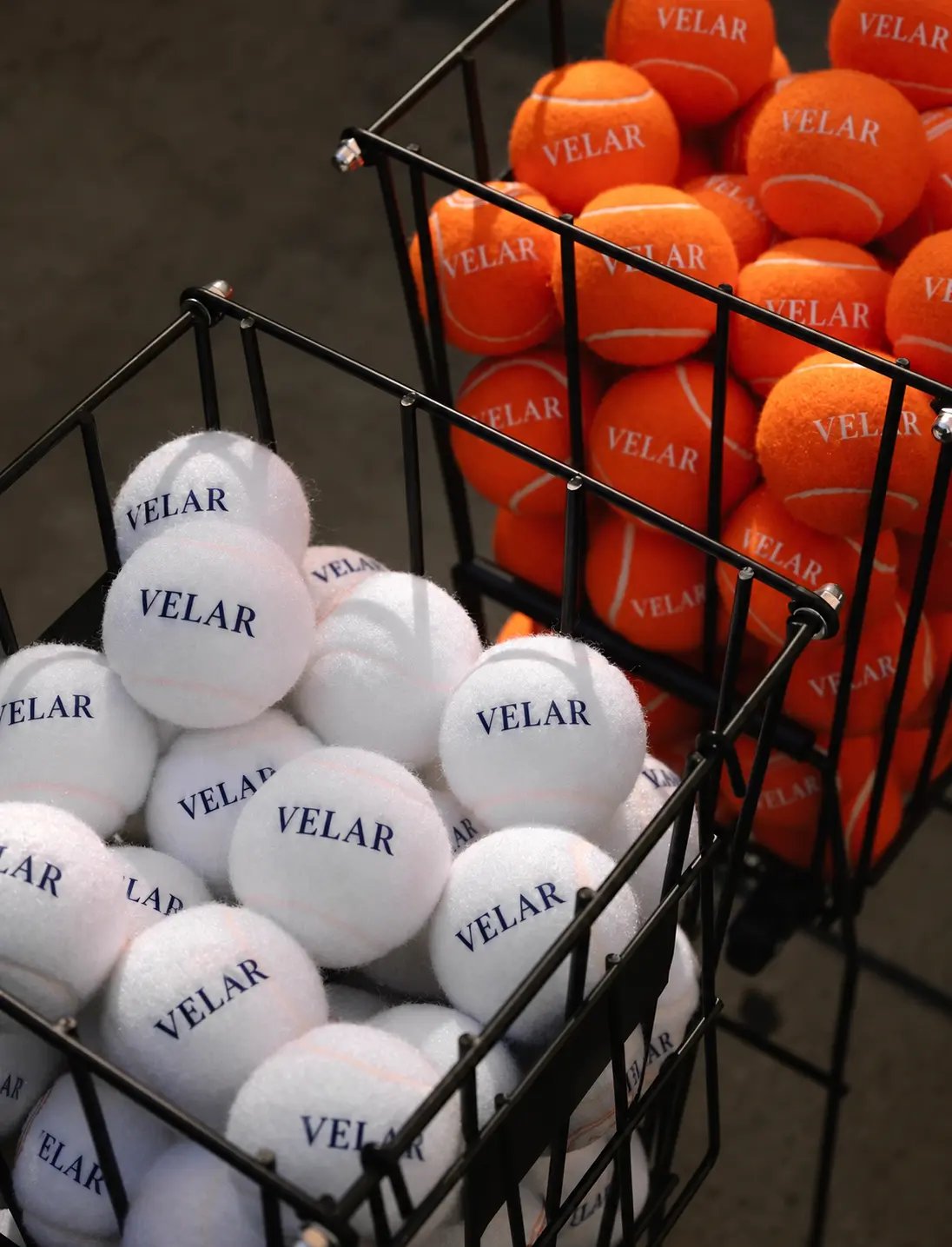 Baskets of white and orange tennis balls ready for practice