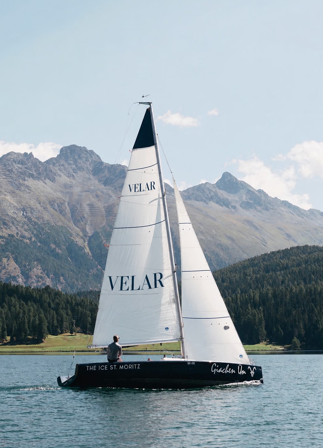 Sailing boat beneath mountains